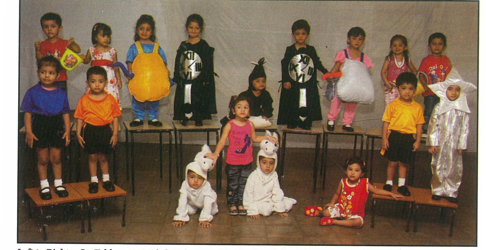 Young NAS children in classroom costumes standing on benches and seated on the floor